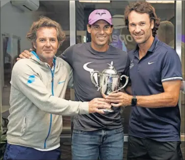 ??  ?? PREMIO. Francis Roig (izda.) y Carlos Moyá posan junto a Nadal con el trofeo a mejores técnicos.