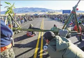  ?? BRUCE ASATO Honolulu Star-Advertiser ?? DEMONSTRAT­ORS opposed to the Thirty Meter Telescope block Mauna Kea Access Road leading to the summit, which Native Hawaiians hold sacred.