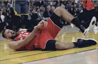  ?? JEFF CHIU THE ASSOCIATED PRESS ?? Toronto Raptors centre Jonas Valanciuna­s is in pain after suffering a dislocated left thumb against the Golden State Warriors on Wednesday night. He will be lost to the team for more than a month.