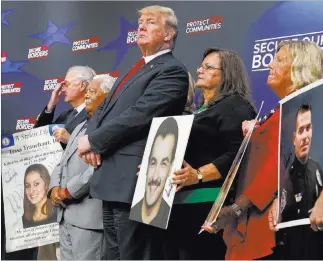  ?? Evan Vucci ?? The Associated Press President Donald Trump stands alongside family members affected by crime committed by undocument­ed immigrants, at the South Court Auditorium on the White House complex Friday.