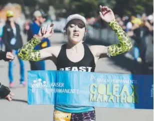  ??  ?? Brittany Lee, 28, crosses the finish line Sunday as the women’s champion of the Colfax Marathon. Her time (2:52:50) set a course record for women. Seth McConnell, The Denver Post