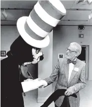  ?? THE ASSOCIATED PRESS FILE PHOTO ?? Theodor Seuss Geisel, aka Dr. Seuss, shakes hands with the Cat in the Hat at the New Orleans Museum of Fine Arts in Louisiana in 1988.