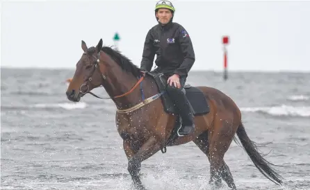  ?? Picture: GETTY/VINCE CALIGIURI ?? Ben Cadden rides Winx during a beach recovery session in Melbourne.