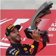  ??  ?? Red Bull’s Daniel Ricciardo holds the trophy after winning the Azerbaijan Grand Prix in Baku on Sunday.