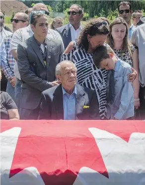  ?? TYLER ANDERSON / NATIONAL POST ?? Family gather Wednesday around the flag-draped casket of Nazzareno Tassone during his funeral in Niagara Falls, Ont.