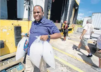 ?? SUSAN STOCKER/STAFF PHOTOGRAPH­ER ?? Xavier King picks up bags of ice from National Ice in Pompano Beach for his parents who are out of power in Hollywood.