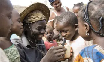  ?? Getty ?? Ghanaian farmer Nuru Ziblim shows children how to ensure water is safe to drink