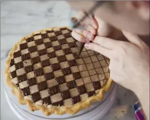  ??  ?? Chris Taylor creates the chocolate squares atop one of his award-winning checkerboa­rd peanut butter pies.