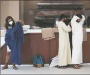  ?? (AP/Marco Ugarte) ?? Actors put on their costumes prior to a Palm Sunday passion play amid the coronaviru­s pandemic outside Iztapalapa Cathe dral, in Iztapalapa, a borough of Mexico City.