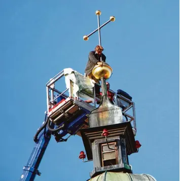  ?? Foto: Hieronymus Schneider ?? Reinhold Geiger fixiert an der Klosterlec­hfelder Wallfahrts­kirche das Kreuz mit der Sockelkuge­l.