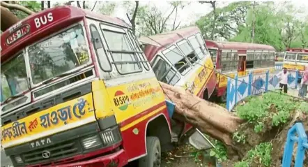  ?? — Reuters ?? Out of service: An uprooted tree crushing a bus after the cyclone in this TV screengrab filmed in Kolkata, India.