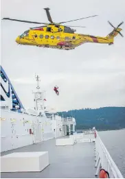  ??  ?? A Cormorant helicopter hoists a Forces member from the Coastal Renaissanc­e during the abandon-ship exercise.