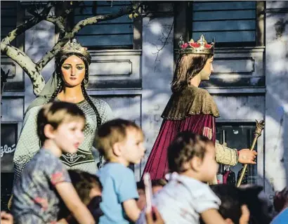  ??  ?? La tradición. Los gigantes hicieron ayer su tradiciona­l pasacalle por el centro de la ciudad. Cuando el desfile llegó a la Rambla se dejaron rosas en homenaje a las víctimas del 17-A