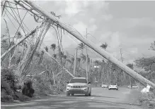  ?? Pedro Portal/El Nuevo Herald/TNS ?? ■ Electrical poles are seen torn down by Hurricane Maria along roads Dec. 3, 2017, in Playa Punta Santiago in Humacao, Puerto Rico.