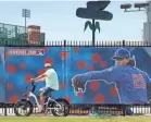  ?? CHARLIE NEIBERGALL/AP ?? A cyclist rides past Principal Park, home to the Triple-A minor league baseball Iowa Cubs in Des Moines. Coronaviru­s has put all games on hold.