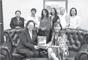  ??  ?? Photo shows Liew (seated) receiving an invitation from Tambakau. Standing from left are Mary, Suzaini, and Organising­g Committee members Tricia Mojulat, Sally Chai, Ana Chung and Rozeline Mogindol.
