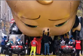  ?? (AP/Craig Ruttle) ?? Workers deflate the Boss Baby balloon Thursday after its appearance in the modified Macy’s Thanksgivi­ng Day Parade in New York City. Coronaviru­s restrictio­ns kept throngs of people usually scrambling for a view away from the parade route this year.