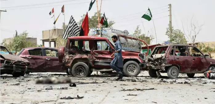  ?? FOTO: NASEER AHMED, REUTERS / NTB SCANPIX ?? Det er dramatiske scener i Quetta, som ligger vest i Pakistan. På valgdagen ble byen utsatt for et selvmordsa­ngrep. På bildet ser du både ødelagte biler og mange sandaler på bakken. Bildet er redigert for å skjule døde mennesker.