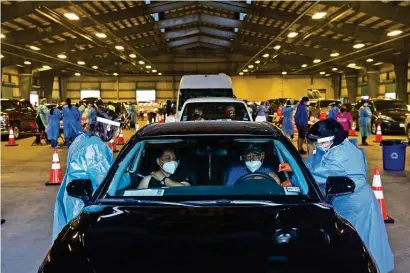  ?? Eddie Seal / Bloomberg ?? Health care workers administer doses of Moderna’s COVID-19 vaccinatio­n at a drive-thru clinic in Robstown.