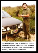  ?? ?? Corporal Wayne Fury picks ears of maize from the radiator grill of his Opel Senator after driving across a field. Note the highvisibi­lity BRIXMIS numberplat­e