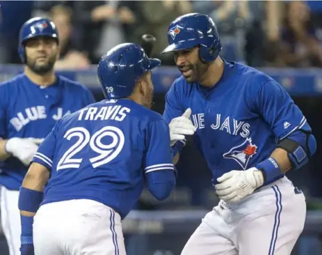 ?? CHRIS YOUNG/THE CANADIAN PRESS ?? Jose Bautista, right, hit his seventh home run in May and Devon Travis extended his hitting streak to 11 games in a win over Texas Saturday.