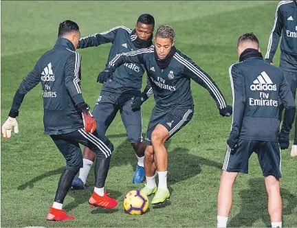  ?? RODRIGO JIMÉNEZ / EFE ?? Esfuerzo. Los jugadores del Real Madrid, Mariano Díaz (con el balón) y el brasileño Vinicius Jr (atrás) durante el entrenamie­nto de ayer en la Ciudad del Fútbol de Valdebebas.