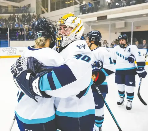  ?? MARK BLINCH / GETTY IMAGES ?? Jade Downie-landry, left, and goaltender Corinne Schroeder of New York celebrate defeating
Toronto 4-0 in their first PWHL hockey game Monday in Toronto.