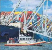  ?? REUTERS ?? A Coast Guard boat carrying senior officers to assess the Francis Scott Key Bridge collapse passes the Singapore-flagged cargo ship Dali in Baltimore, Maryland, US, on Friday.