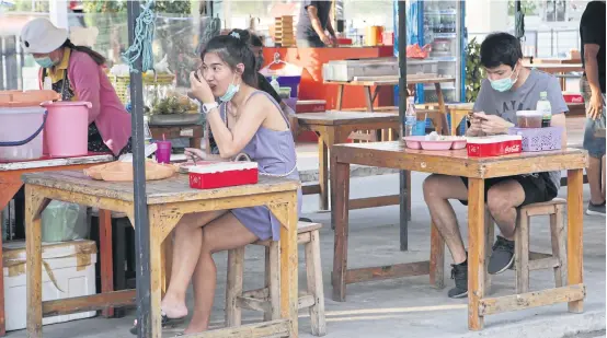  ?? APICHIT JINAKUL ?? Distant diners
Customers at this food outlet next to the EkamaiRami­ntra expressway in Tha Raeng area of Bang Khen district yesterday sit separately at tables specially spaced to prevent Covid-19 infection after the government eased its lockdown and allowed it to reopen on Sunday.