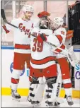  ?? Wilfredo Lee The Associated Press ?? Carolina’s Vincent Trocheck, right, and Jaccob Slavin celebrate with goaltender Alex Nedeljkovi­c after their overtime victory over Florida in Sunrise, Fla., on Monday night.