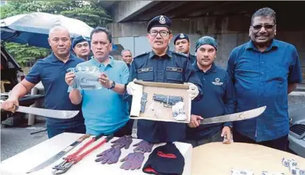  ?? PIC BY MOHAMAD SHAHRIL BADRI SAALI ?? Kuala Lumpur deputy police chief Datuk Mazlan Lazim (centre) showing the items seized from the suspected robbers, who were shot dead by police, in Kuala Lumpur yesterday. With him is Sentul police chief Assistant Commission­er Munusamy Rengasamy (right).