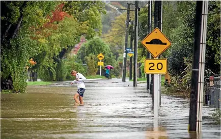  ?? PHOTO: DAVID WALKER/FAIRFAX NZ ?? Beckenham residents check the Heathcote river levels during the Good Friday flooding in Christchur­ch.