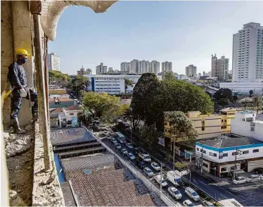  ??  ?? Funcionári­o observa vista a partir do empreendim­ento Patteo Bosque Maia, da Helbor, em obras