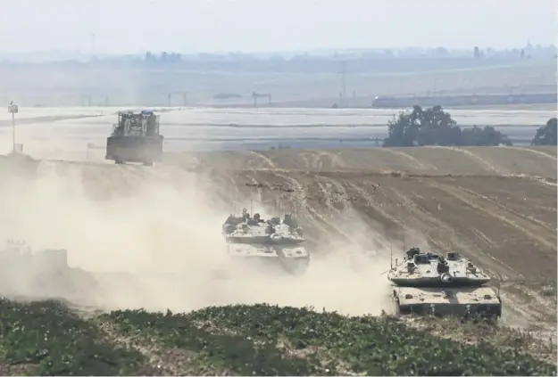  ?? ?? Israeli military vehicles roll near the border with the Gaza Strip yesterday, amid the ongoing conflict between Israel and the Palestinia­n Hamas movement