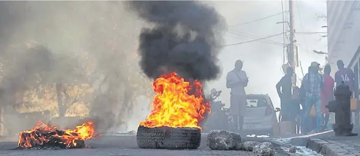  ?? AFP ?? Protesta. Neumáticos en llamas cerca de la prisión principal de Puerto Príncipe, la capital de Haití, después de una fuga de varios miles de reclusos tras un ataque de pandillas.