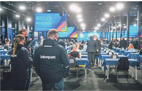  ?? FOTO: SCHÜRMANN/GETTY IMAGES ?? Mitarbeite­r des Ordnungsam­tes der Stadt Kalkar kontrollie­rten beim Afd-parteitag die Einhaltung der Masken- und Abstandsre­geln.