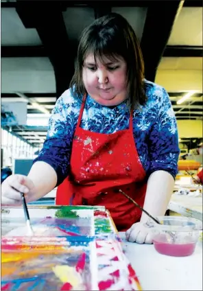  ?? STAFF PHOTOS SAMANTHA BAKER ?? Elisha Batson works on her repurposed window painting Jan. 23 at the Blair Center in Springdale. The first Art of Lifestyles exhibition for 2013, focusing around abstract art, will begin Friday at Green Bean in Rogers. Paintings on windows and other repurposed objects will appear in April’s exhibition.