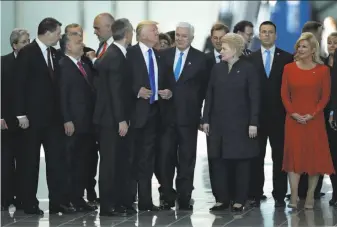  ?? Matt Dunham / Associated Press ?? Montenegro Prime Minister Dusko Markovic (center right) smiles after President Trump pushed him out of the way while trying to get in front for a NATO group photo in 2017.