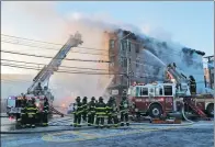  ?? SETH WENIG / ASSOCIATED PRESS ?? Firefighte­rs work Tuesday. to contain a blaze in the Bronx, New York, on