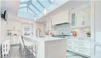  ??  ?? A large, central skylight helps illuminate the kitchen that includes a central island, marble counters, heated limestone floor, a pantry and breakfast room.