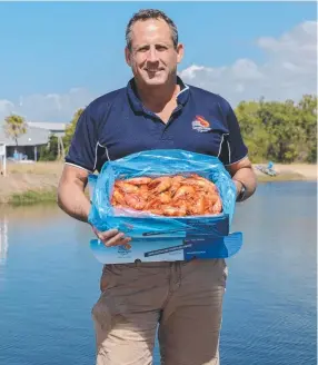  ?? TOP EATING: Pacific Reef Fisheries general manager John Moloney with some of the prawns from the aquacultur­e farm near Ayr. ??