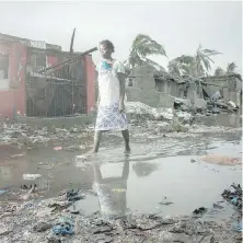  ??  ?? A woman walks through the flooded streets of the city of Beira, Mozambique, in the wake of Cyclone Idai.