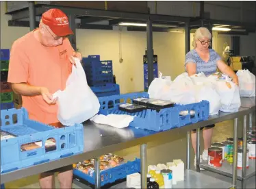  ?? Leslie Hutchison/ Hearst Connecticu­t Media ?? Paul Chiappa and Kathy Pelchat work in the food storage building, across the street from the Sullivan Senior Center, to sort meals based on clients’ dietary needs.