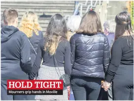  ??  ?? HOLD TIGHT Mourners grip hands in Moville