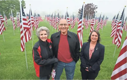  ?? MICHAEL SEARS / MILWAUKEE JOURNAL SENTINEL ?? Rotary Club of Mitchell Field members Jerrianne Hayslett (from left), her husband Hibbie Hayslett, both of South Milwaukee, and Tamara Morgan of Cudahy stand in front of the 200 flags on display in front of the Oak Creek Community Center, 8580 S....
