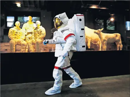  ?? [FRED SQUILLANTE/DISPATCH] ?? Dressed as a moon-walking astronaut, Matt Brady of the Mascot Organizati­on walks past the latest Ohio State Fair butter sculpture inside the Dairy Products Building at the Ohio Expo Center.