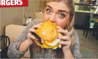  ?? Picture: MARK CALLEJA ?? MESSY BUSINESS: Courtney Judd, 21, tucks into a true Aussie burger.