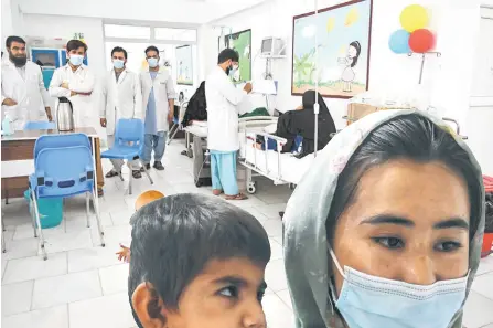  ?? ?? Doctors treating patients in the critical care section of the malnutriti­on ward at the Boost Hospital.