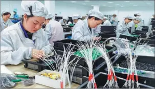  ?? PAN JIANYONG / XINHUA ?? Employees work at a small firm that makes communicat­ion products in Meishan, Sichuan province.