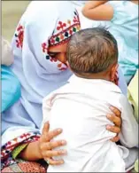  ?? RIZWAN TABASSUM/AFP ?? A Pakistani woman holds her HIV infected child as she sits outside her house in Rato Dero in the district of Larkana of the southern Sindh province.